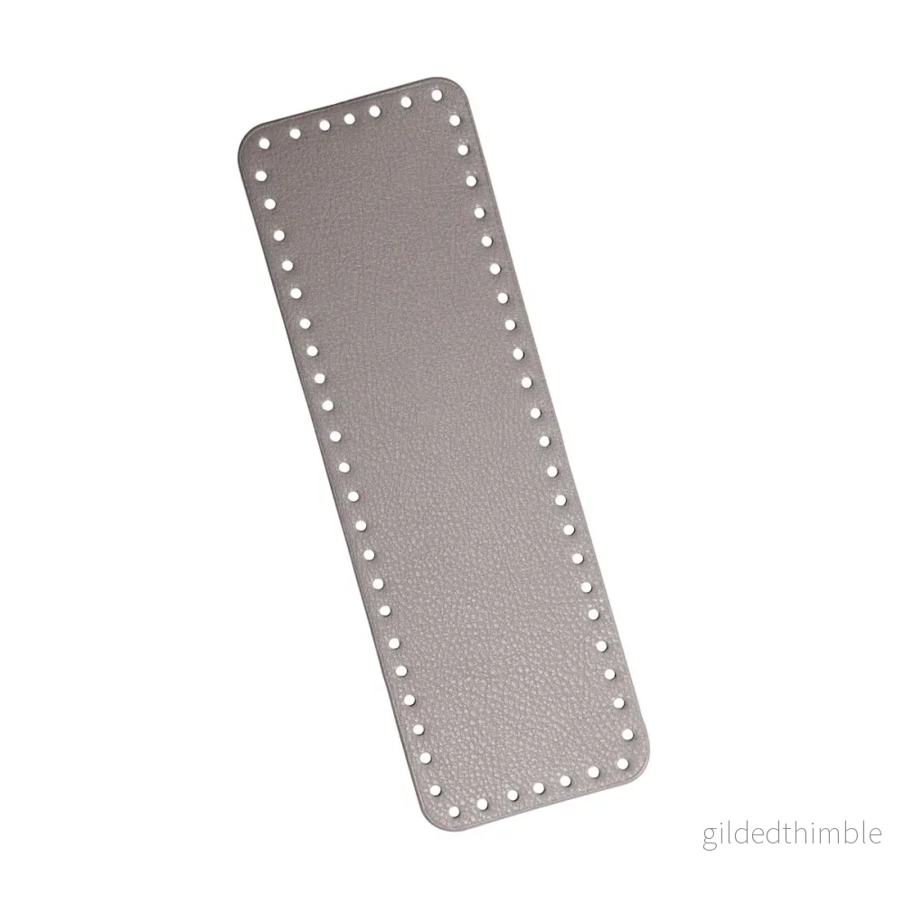 Väskbotten i gråbeige konstläder 31×10 cm.