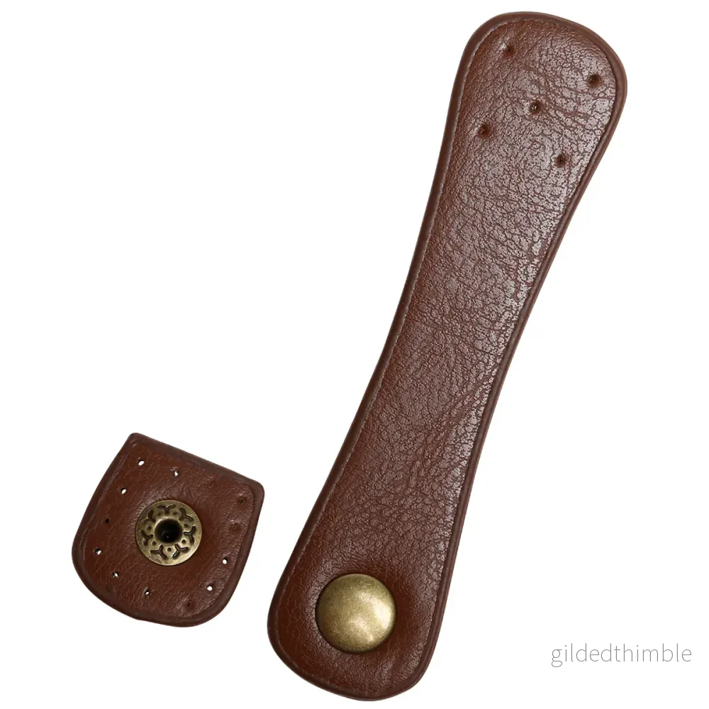 Flap-lock konstläder brun med tryckknapp i antikbrons Flap-lock konstläder brun med tryckknapp i antikbrons
