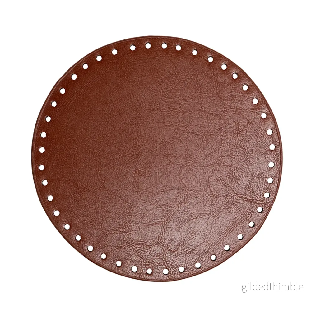 Väskbotten i brun konstläder rund 20 cm.